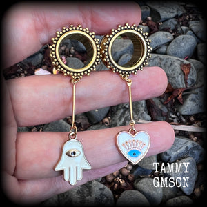These tunnel earrings feature gold enamel hamsa hand and evil eye charms, weighing approx 9 grams each and measuring just over 6cms.
This pair have been made with 5/8" (16mm) gauge ornate titanium coated surgical steel screw fit tunnels.