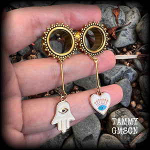 These tunnel earrings feature gold enamel hamsa hand and evil eye charms, weighing approx 9 grams each and measuring just over 6cms.
This pair have been made with 5/8" (16mm) gauge ornate titanium coated surgical steel screw fit tunnels.