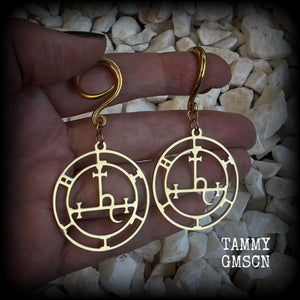 These gorgeous gold stainless steel earrings feature the Sigil of Lilith as it appears in The Lesser Key of Solomon, and are lovely and light weight, weighing only 7 grams each, and measure just on 7cms from tip to tip.

This pair has been made with 6 gauge (4mm) surgical steel full curl hooks, to be worn in stretched lobes..