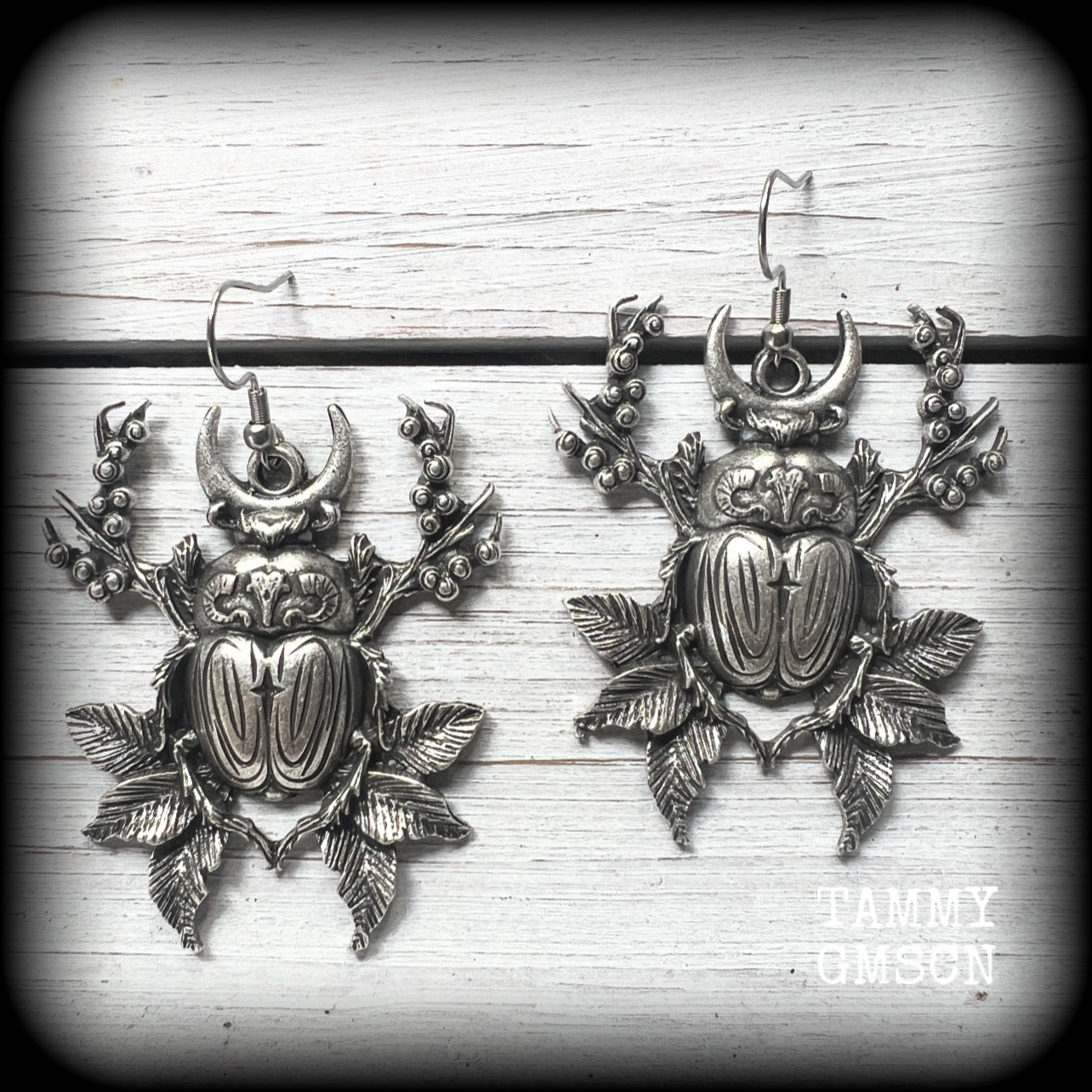 These gorgeous earrings feature big beautiful antique silver beetles surrounded by berries and leaves, weighing 14 grams each and measuring just on 6.5cms from tip to tip.

This pair have been made on stainless steel french hooks, suitable for pierced ears.