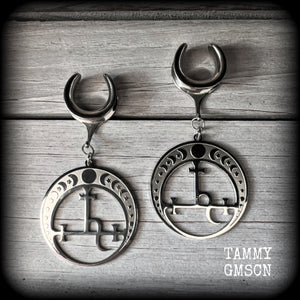 These gorgeous stainless steel earrings feature the Sigil of Lilith surrounded by moon phases, lovely and light weight at only 9 grams each, and measure just over 7cms from tip to tip.

This pair has been made on 5/8” gauge (16mm) surgical steel cradles, for stretched lobes.