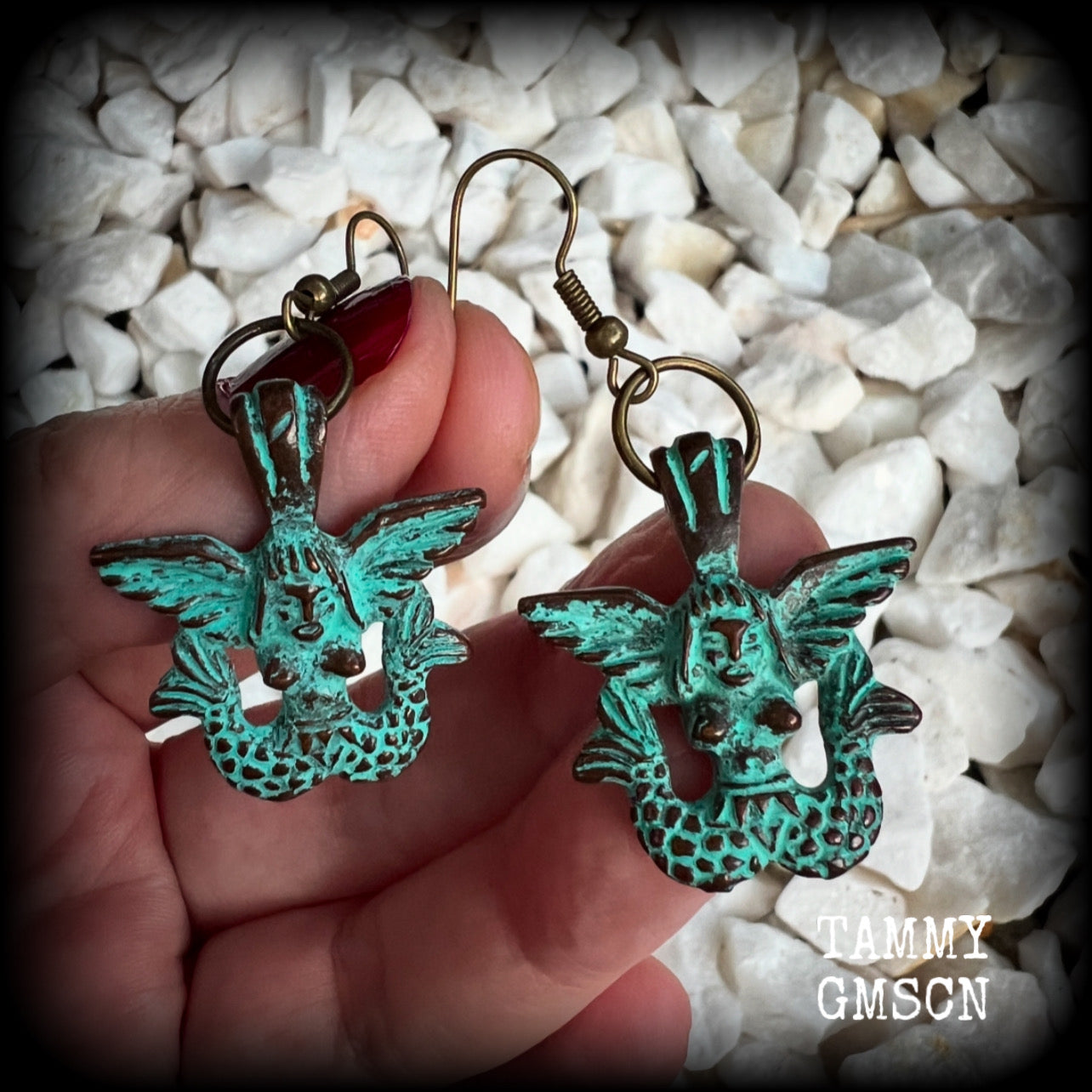 These unique earrings feature a pair of green patina double tail mermaids, measuring just over 5 cms from tip to tip, and weighing only 6 grams each.  This pair has been made on antique bronze french hooks, suitable for pierced ears or stretched lobes.