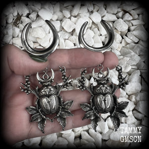 These gorgeous earrings feature large antique silver scarab beetles surrounded by berries and leaves with a crescent moon, measuring just on 9cms from tip to tip, and weighing 20 grams a piece.  This pair has been made on 1” gauge (25mm) gauge surgical steel cradles, to be worn in stretched lobes.