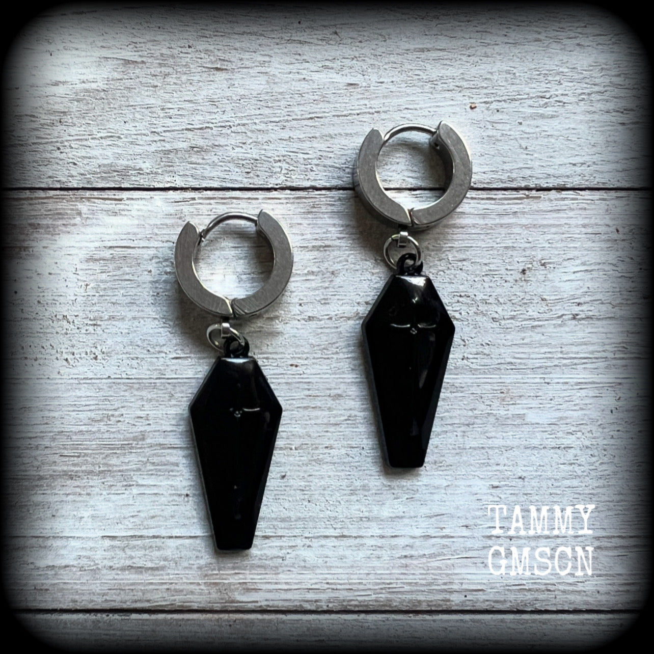 These awesome earrings feature gorgeous black enamel coffins, are nice and lightweight at 3 grams each, and measure in at just over 4cms from tip to tip.

This pair have been made on stainless steel huggie ear cuffs, suitable for pierced ears.
