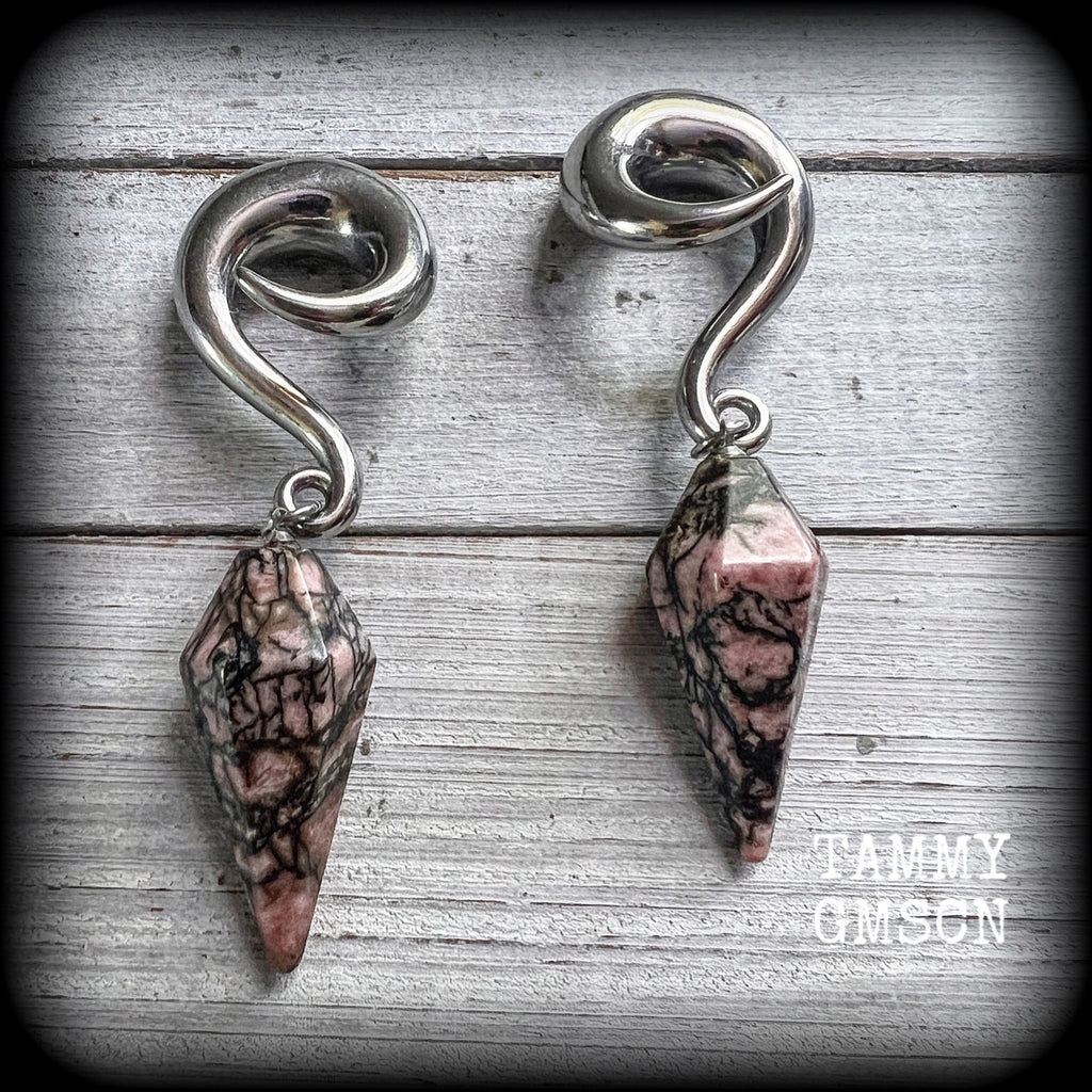 This is a pair of beautiful Rhodonite gauged earrings, featuring a pair of one of a kind dusty pink and chocolate brown gemstones, weighing approx 30 grams a piece, and measuring approx 8cms from tip to tip.
