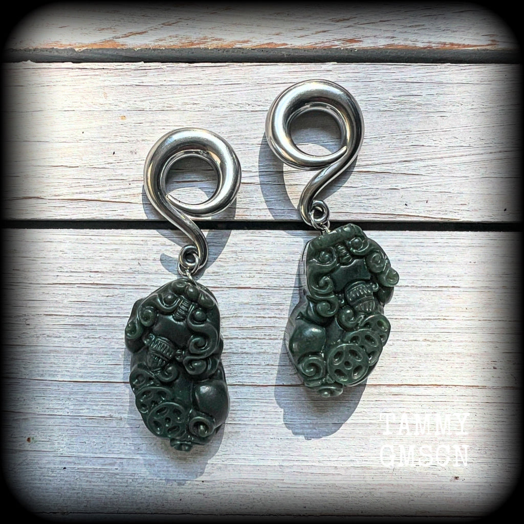 These gorgeous earrings are made from carved Lantian jade featuring the beautiful mythological lion dog, the Pi Xiu, weighing approx 34 grams a piece and measure just over 7cms from tip to tip.

This pair have been made with 0 gauge (8mm) surgical steel full curl hooks, to be worn in stretched lobes.