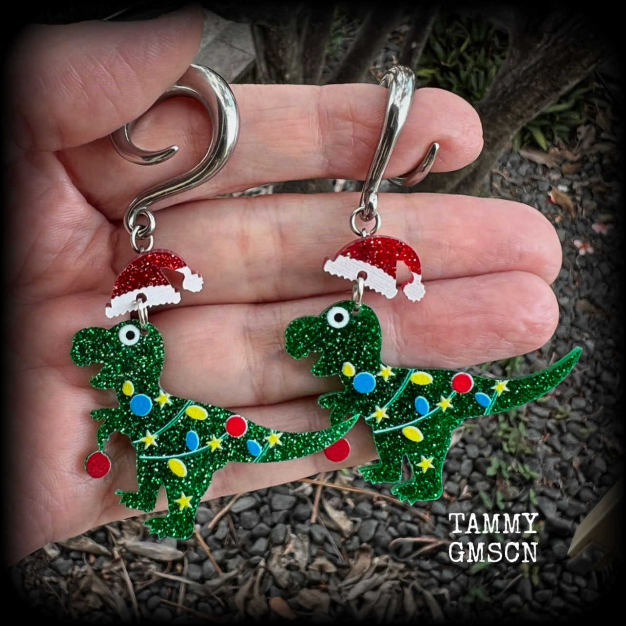 Featuring festive dinosaurs draped in colourful Christmas tree lights complete with Santa hats, these adorable earrings weigh in at 9 grams a piece, and measure approx 8cms from tip to tip.  This pair has been made on 2 gauge (6mm) surgical steel full curl hooks, to be worn in stretched lobes.