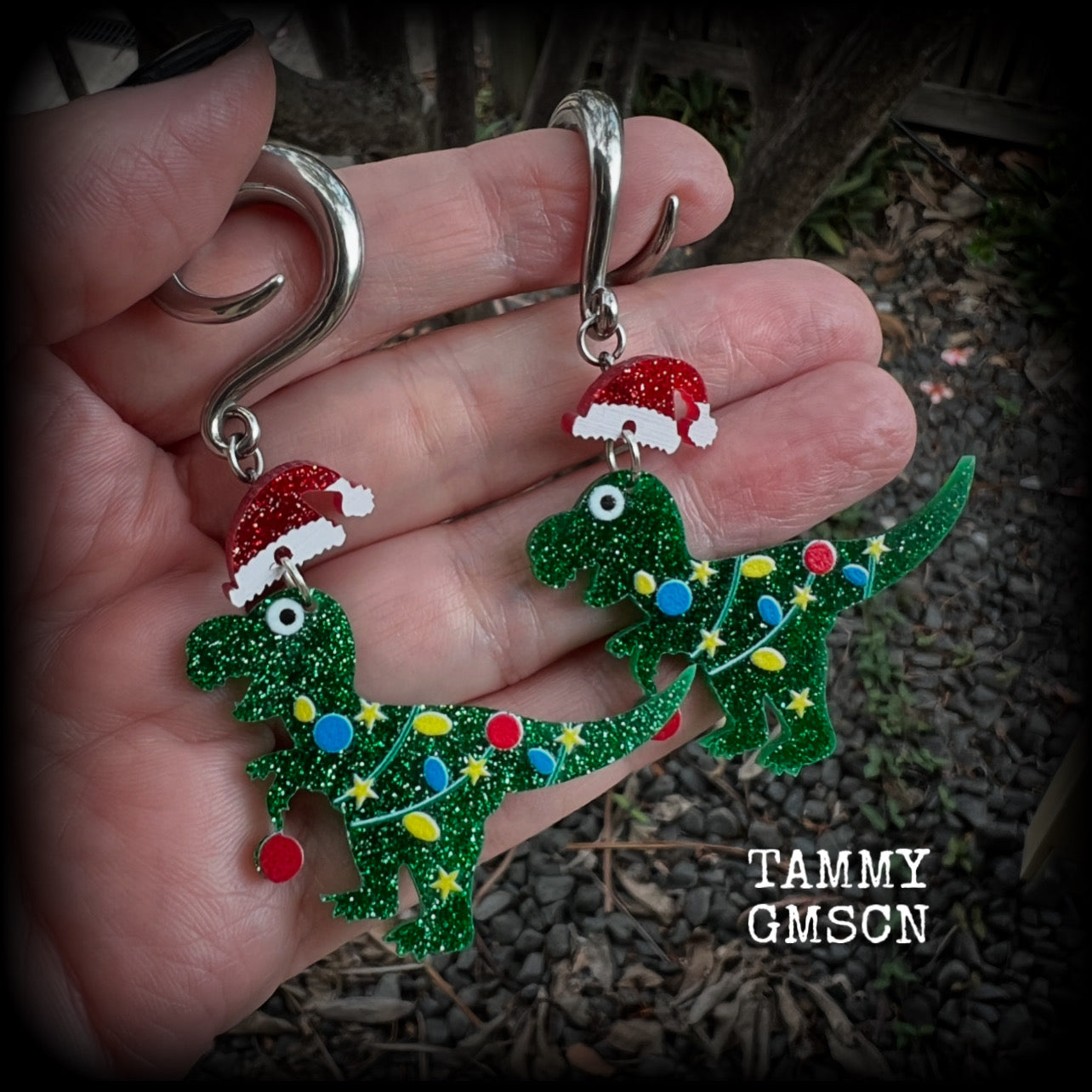 Featuring festive dinosaurs draped in colourful Christmas tree lights complete with Santa hats, these adorable earrings weigh in at 9 grams a piece, and measure approx 8cms from tip to tip.  This pair has been made on 2 gauge (6mm) surgical steel full curl hooks, to be worn in stretched lobes.