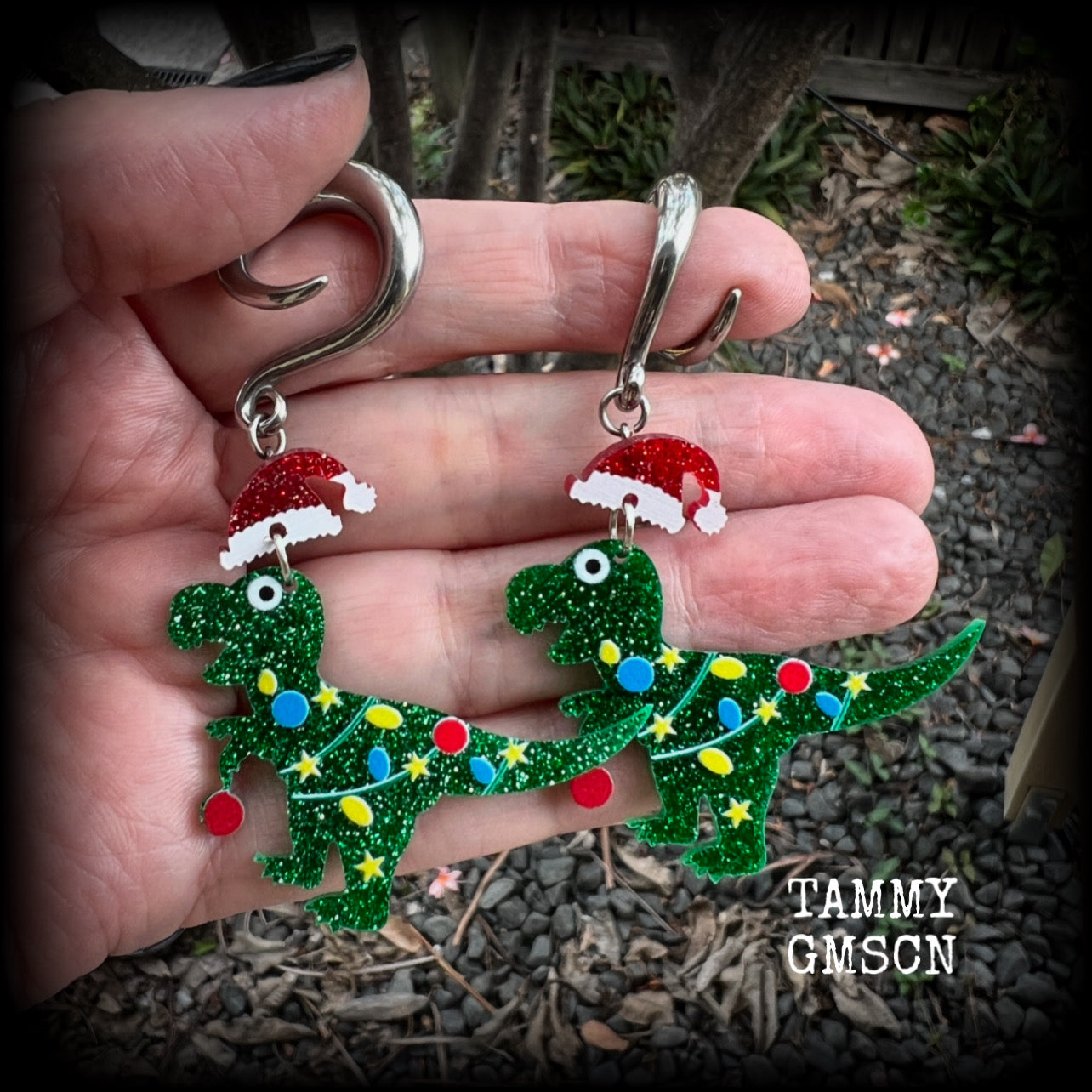 Featuring festive dinosaurs draped in colourful Christmas tree lights complete with Santa hats, these adorable earrings weigh in at 9 grams a piece, and measure approx 8cms from tip to tip.  This pair has been made on 2 gauge (6mm) surgical steel full curl hooks, to be worn in stretched lobes.