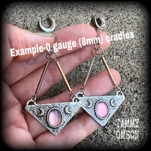 Featuring an inverted triangle with crescent moons and a single translucent purple cabachon, measuring just over 7 cms from tip to tip, and weighing approx 8 grams each.
This pair has been made on 0 gauge surgical steel cradles