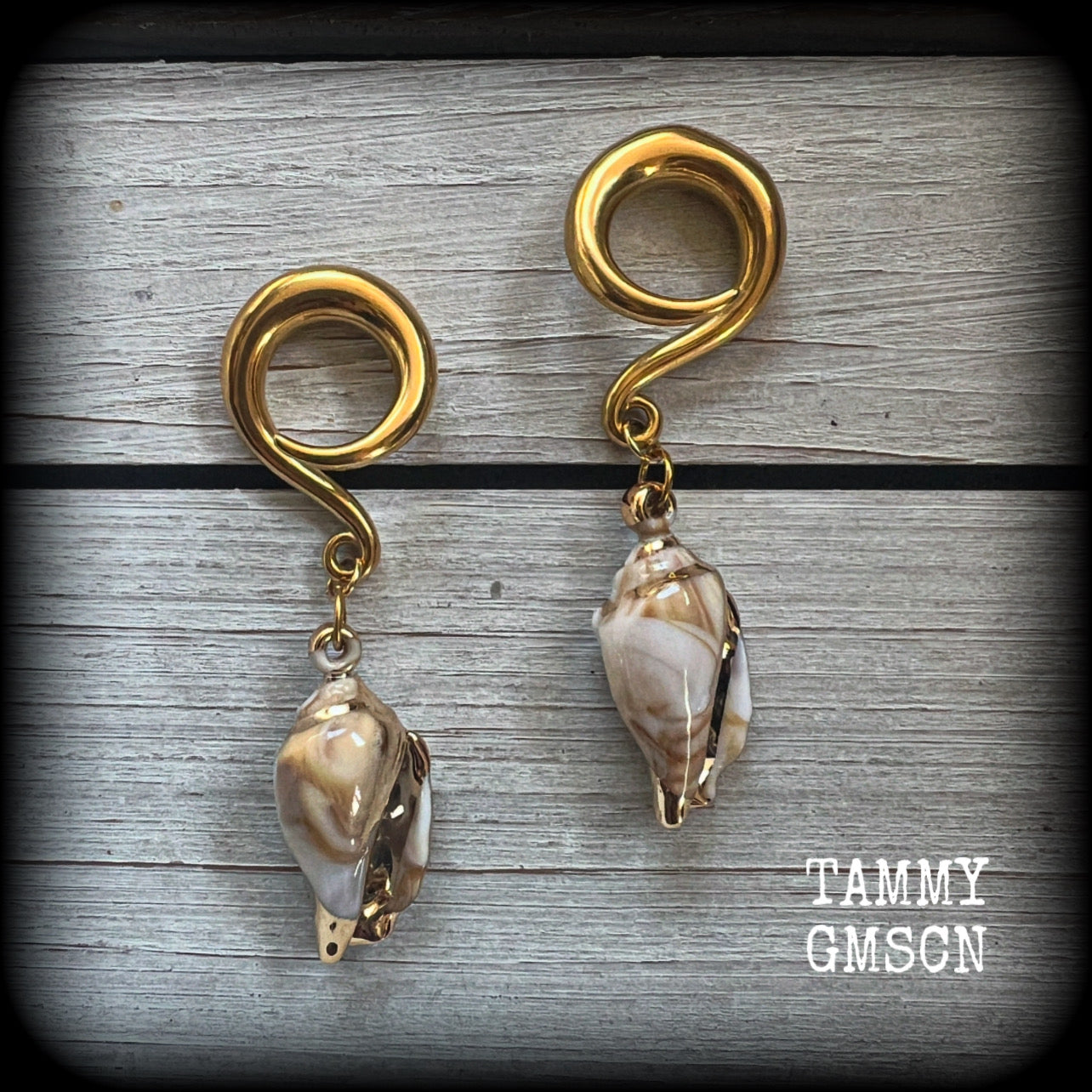 These gauged earrings feature gorgeous acrylic conch sea shells, super lightweight- weighing 10 grams each, and nice and dangly, measuring just on 7cms from tip to tip. 

These beautiful earrings have been made on 2 gauge (6mm) surgical steel full curl hooks, to be worn in stretched lobes.