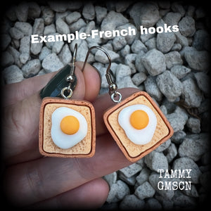 These pair of adorable earrings features eggs on bread!! Measuring just on 4cms from tip to tip, these earrings are nice and dangly and nice and light weight at only a few grams each.

This pair has been made with stainless steel french hooks for pierced ears.
