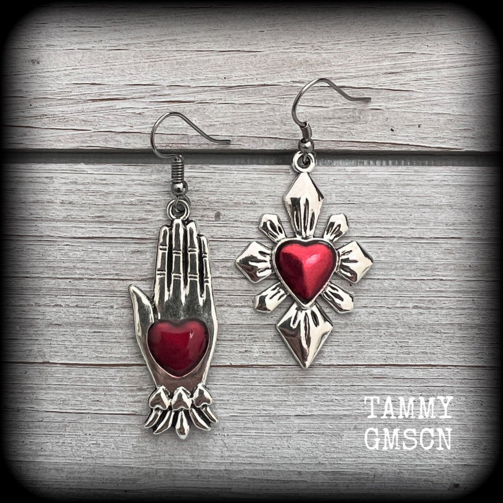 These beautiful red enamel and antique silver earrings feature a sacred heart with a sacred hand, are nice and lightweight at approx 5 grams a piece, measuring just on 6cms from tip to tip.

This pair has been made on stainless steel french hooks to be worn through pierced ears.