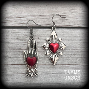 These beautiful red enamel and antique silver earrings feature a sacred heart with a sacred hand, are nice and lightweight at approx 5 grams a piece, measuring just on 6cms from tip to tip.

This pair has been made on stainless steel french hooks to be worn through pierced ears.