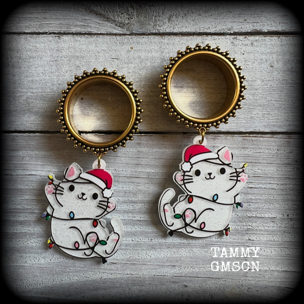 These festive tunnel earrings feature mischievous white cats in santa hats draped in Christmas lights, are nice and lightweight approx 12 grams each and measure just over 7cms from tip to tip.

This pair has been made on 1” gauge (25mm) gauge ornate surgical steel screw fit tunnels-for stretched lobes.