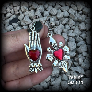 These beautiful red enamel and antique silver earrings feature a sacred heart with a sacred hand, are nice and lightweight at approx 5 grams a piece, measuring just on 6cms from tip to tip.

This pair has been made on stainless steel french hooks to be worn through pierced ears.