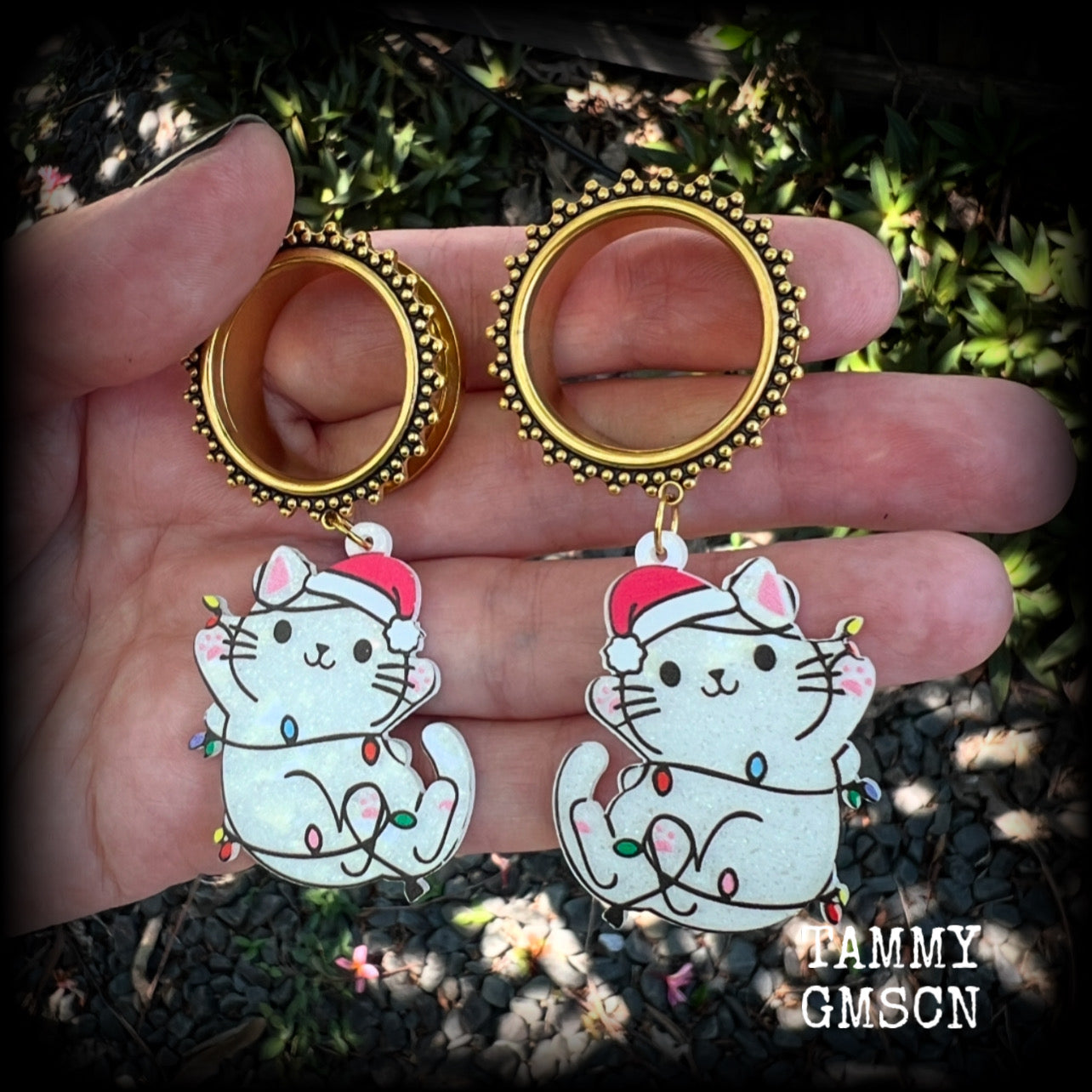 These festive tunnel earrings feature mischievous white cats in santa hats draped in Christmas lights, are nice and lightweight approx 12 grams each and measure just over 7cms from tip to tip.

This pair has been made on 1” gauge (25mm) gauge ornate surgical steel screw fit tunnels-for stretched lobes.