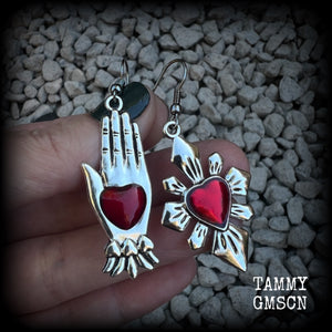 These beautiful red enamel and antique silver earrings feature a sacred heart with a sacred hand, are nice and lightweight at approx 5 grams a piece, measuring just on 6cms from tip to tip.

This pair has been made on stainless steel french hooks to be worn through pierced ears.