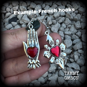 These beautiful red enamel and antique silver earrings feature a sacred heart with a sacred hand, are nice and lightweight at approx 5 grams a piece, measuring just on 6cms from tip to tip.

This pair has been made on stainless steel french hooks to be worn through pierced ears.