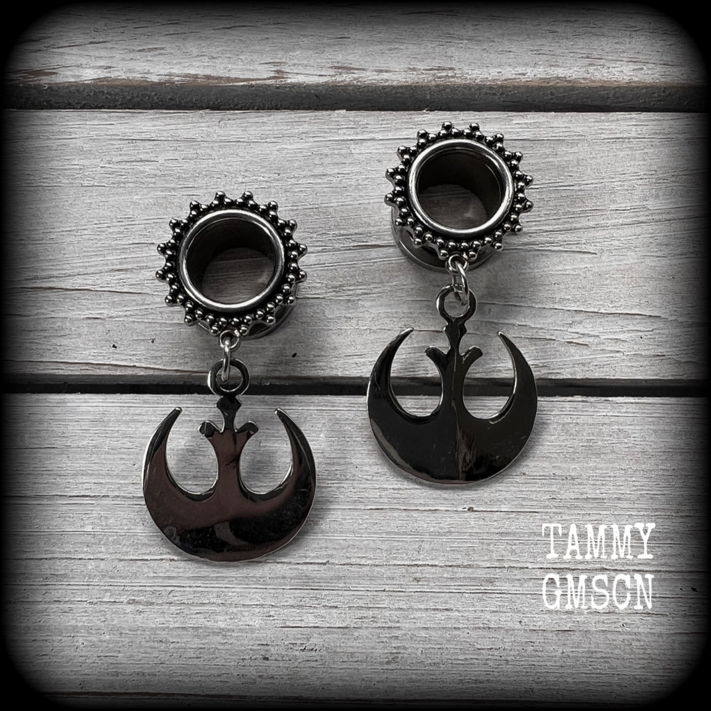 This pair of awesome Star Wars tunnel earrings features an antique silver Rebel Alliance symbol, measuring just on 5 cms from tip to tip, and weighing approx 7grams a piece. 

This pair has been made with gorgeous boho 1/2” gauge (12mm) ornate surgical steel screw fit tunnels, suitable for stretched lobes. 