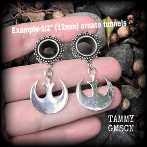 This pair of awesome Star Wars tunnel earrings features an antique silver Rebel Alliance symbol, measuring just on 5 cms from tip to tip, and weighing approx 7grams a piece. 

This pair has been made with gorgeous boho 1/2” gauge (12mm) ornate surgical steel screw fit tunnels, suitable for stretched lobes. 