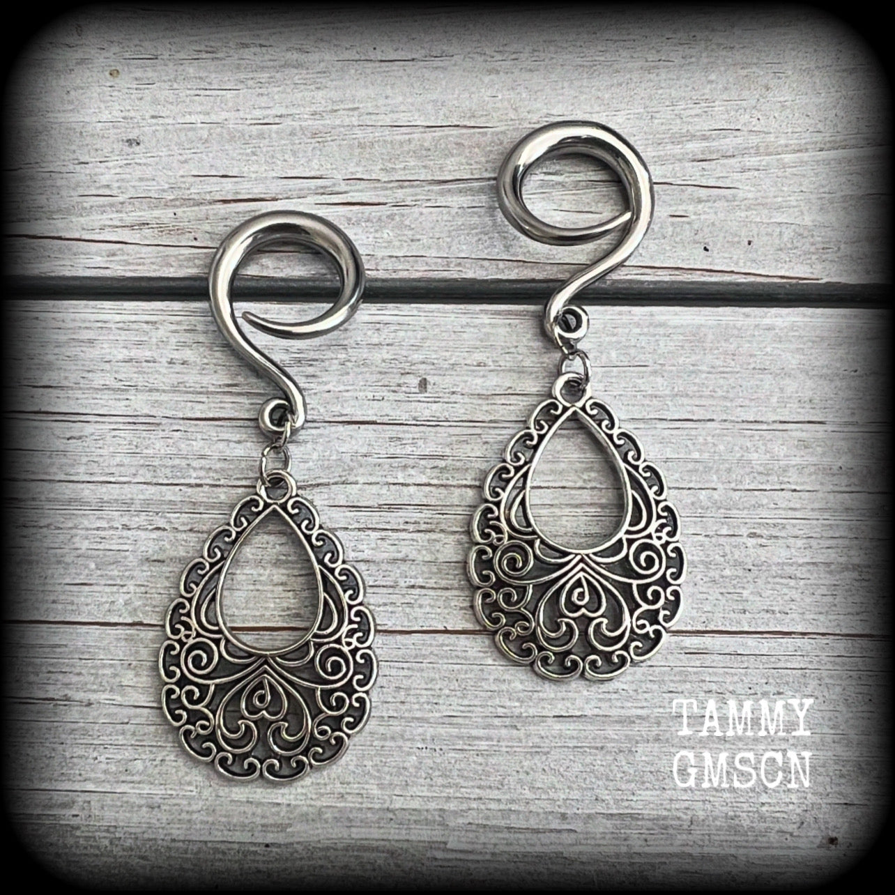 These beautiful ornate ear hangers feature antique silver filigree teardrop mandalas, inspired by Aphrodite, the Greek Goddess of love and beauty.
These earrings nice and light weight, weighing approx 6 grams a piece and measure just on 6.5cms from tip to tip.

This pair has been made on 6 gauge (4mm) surgical steel full curl hooks, suitable for stretched lobes.