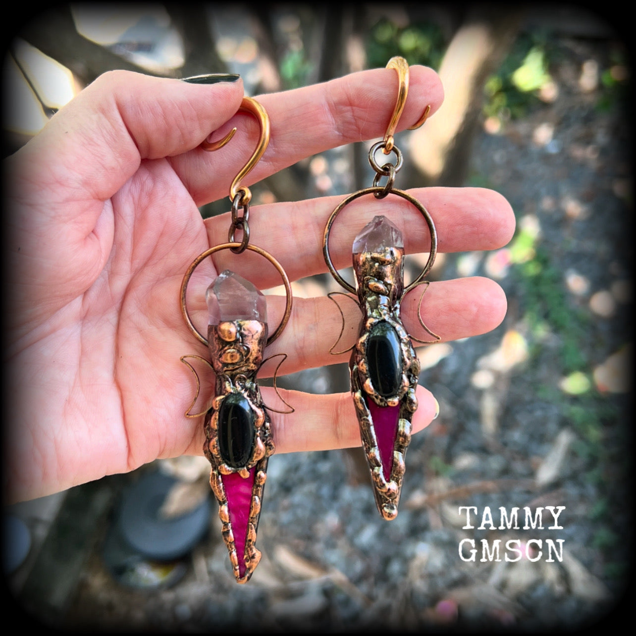 These pink quartz and black obsidian gauged earrings are stunning!!

Featuring gorgeous black obsidian gemstones with pink quartz gemstones in a rustic antique copper crescent moon setting, these gauged earrings measure just on 11.5 from tip to tip, and weigh approx 27 grams each.
 
This pair has been made on 6 gauge (4mm) rose tone surgical steel full curl hooks, suitable to be worn in stretched lobes.
