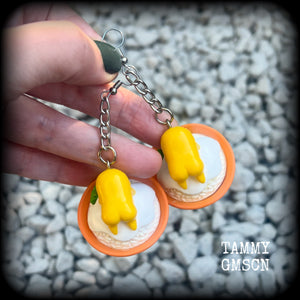 These earrings are TOO CUTE!!! Featuring the adorable Gudetama lazy egg man himself laying on a bowl of rice with a dash of wasabi, these earrings measure just on 8cms and weighing approx 20 grams.

This pair has been made on stainless steel french hooks, suitable for pierced ears.
