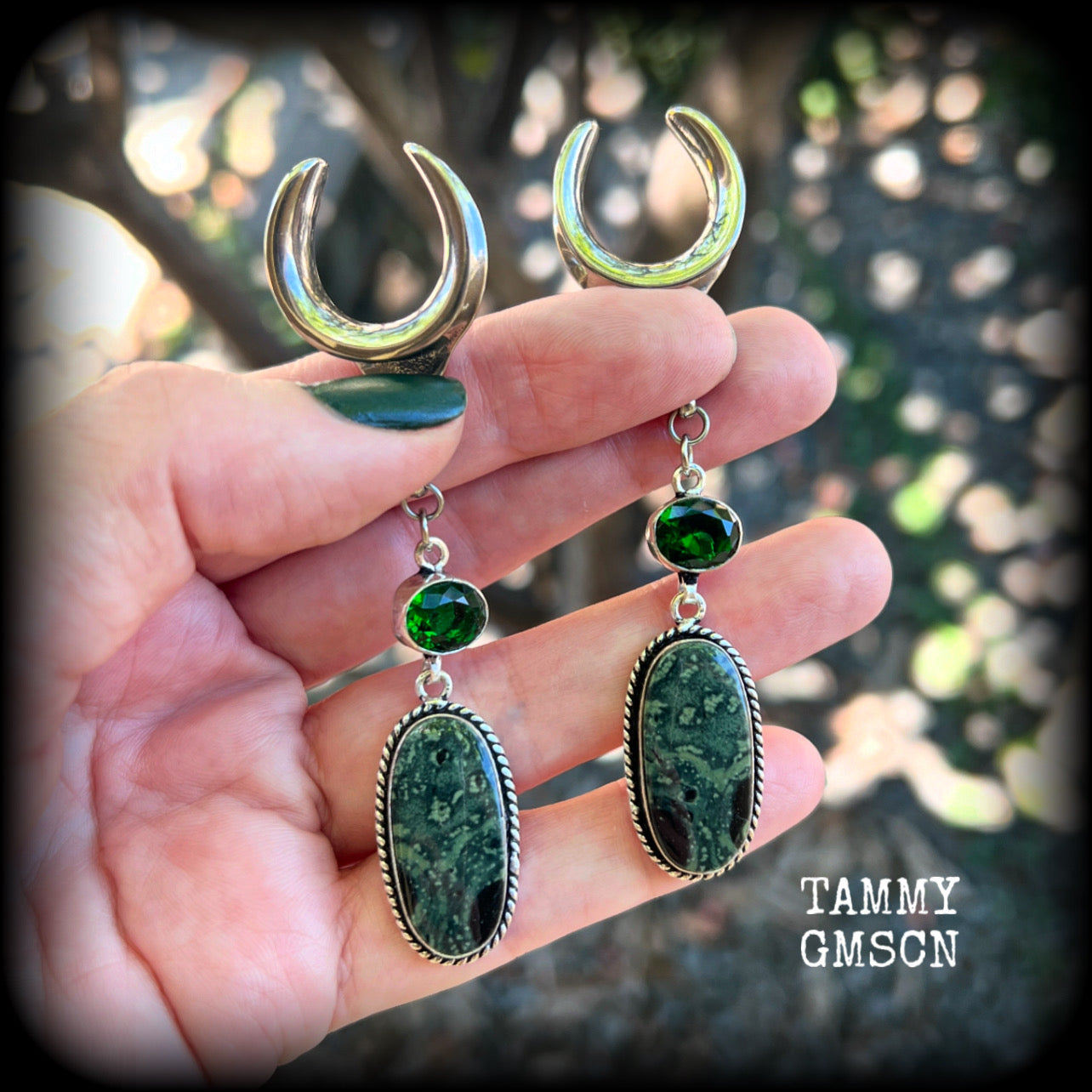 🖤 Kambaba jasper is a type of volcanic rock with orbs of fossilized algae that have been encased within it, known for providing a sense of calm, balance, and safety, and is often used in meditation 🖤

Featuring gorgeous green and black polished jasper stones hanging from deep green quartz crystals, these earrings measure just under 9cms from tip to tip, and weigh approx 12 grams each.

This pair have been made on 3/4” gauge (19mm) surgical steel cradles, suitable for stretched lobes.
