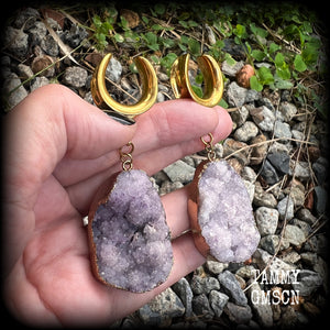This is a pair of dusty purple druzy earrings featuring real druzy gems in an antique gold setting.
Measuring just 7.5 cms from tip to tip, and weighing approx 25 & 35 grams each.
This pair has been made on 3/4” gauge (19mm) surgical steel cradles.