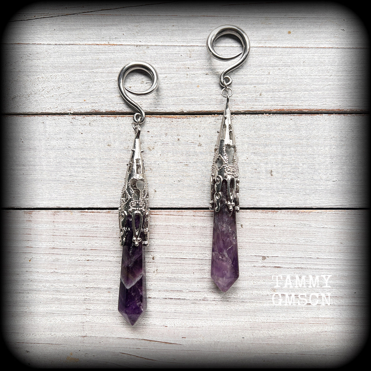 These gorgeous gothic gauged earrings feature a pair of beautiful long purple amethysts set in an antique silver setting, weighing approx 19 grams a piece and measuring approx 11cms from tip to tip.

This pair has been made on 6 gauge (4mm) surgical steel full curl hooks, to be worn in stretched lobes.