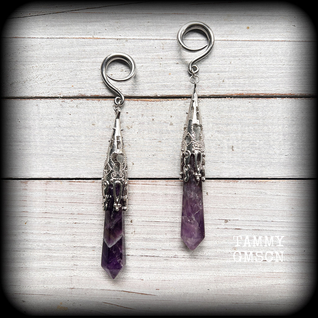 These gorgeous gothic gauged earrings feature a pair of beautiful long purple amethysts set in an antique silver setting, weighing approx 19 grams a piece and measuring approx 11cms from tip to tip.

This pair has been made on 6 gauge (4mm) surgical steel full curl hooks, to be worn in stretched lobes.