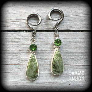 These beautiful Serpentine and green garnet earrings are made with gorgeous polished and faceted gemstones, lovely and dangly measuring just approx 7.5cms from tip to tip, and weighing approx 9 grams each. 

These earrings have been made on 6 gauge (4mm) surgical steel full curl hooks, to be worn in stretched lobes.
