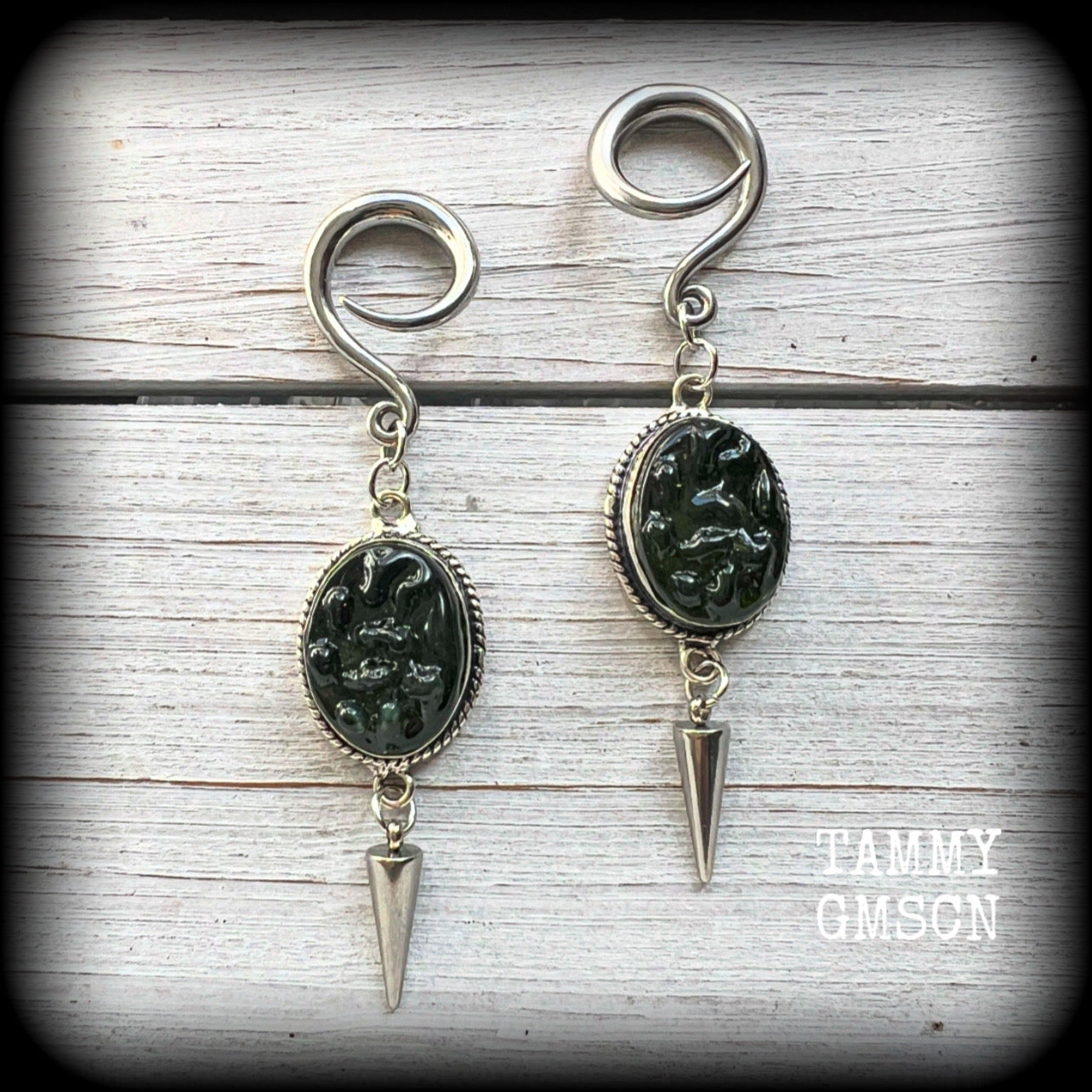 This pair of earrings features gorgeous forest green moldavite gemstones in a boho antique silver setting, weighing approx 10 grams a piece and measuring just on 8cms from tip to tip.

This pair have been made on 6 gauge (4mm) surgical steel full curl hooks, to be worn in stretched lobes.