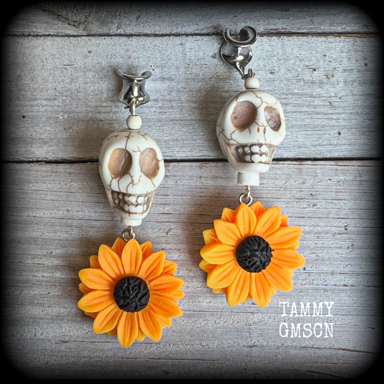 Featuring gorgeous orange sunflowers hanging beneath large bone white stone skulls, these earrings are big and beautiful !! 

These earrings weigh in at around 16 grams a piece, and nice and dangly at just under 8.5cms from tip to tip.

This pair have been made with 0 gauge (8mm) surgical steel cradles, suitable for stretched lobes.