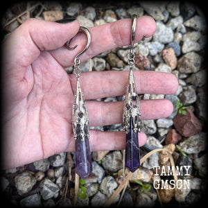 These gorgeous gothic gauged earrings feature a pair of beautiful long purple amethysts set in an antique silver setting, weighing approx 19 grams a piece and measuring approx 11cms from tip to tip.

This pair has been made on 6 gauge (4mm) surgical steel full curl hooks, to be worn in stretched lobes.