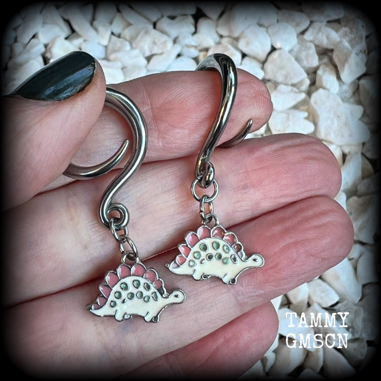 These adorable pink and white enamel stegosaurus gauged earrings are nice and light weight at approx 5 grams a piece, and nice and dangly at just under 5cms from tip to tip.

This pair has been made on 6 gauge (4mm) surgical steel full curl hooks, to be worn in stretched lobes.