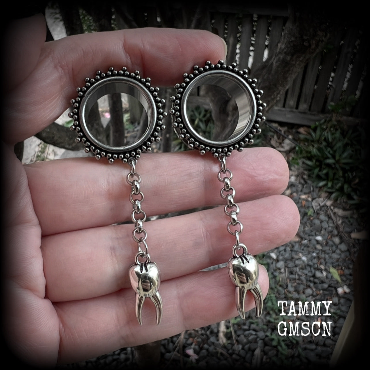 These gorgeous spooky tunnel dangles feature a classic antique silver molar tooth dangling from stainless steel chain, weighing approx 5 grams each and measuring 7cms from tip to tip.

This pair has made with 3/4" gauge (19mm) ornate surgical steel screw fit tunnels.