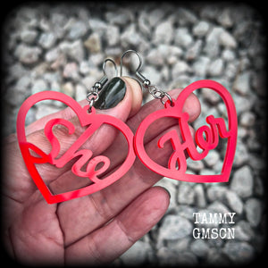 These earrings feature gorgeous bright red hearts showing the pronouns SHE/HER. 
These are nice and lightweight (at only a few grams each), and measure approx 6.5cms from tip to tip.

This pair have been made on stainless steel french hooks, for pierced ears.