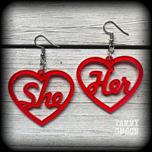 These earrings feature gorgeous bright red hearts showing the pronouns SHE/HER. 
These are nice and lightweight (at only a few grams each), and measure approx 6.5cms from tip to tip.

This pair have been made on stainless steel french hooks, for pierced ears.