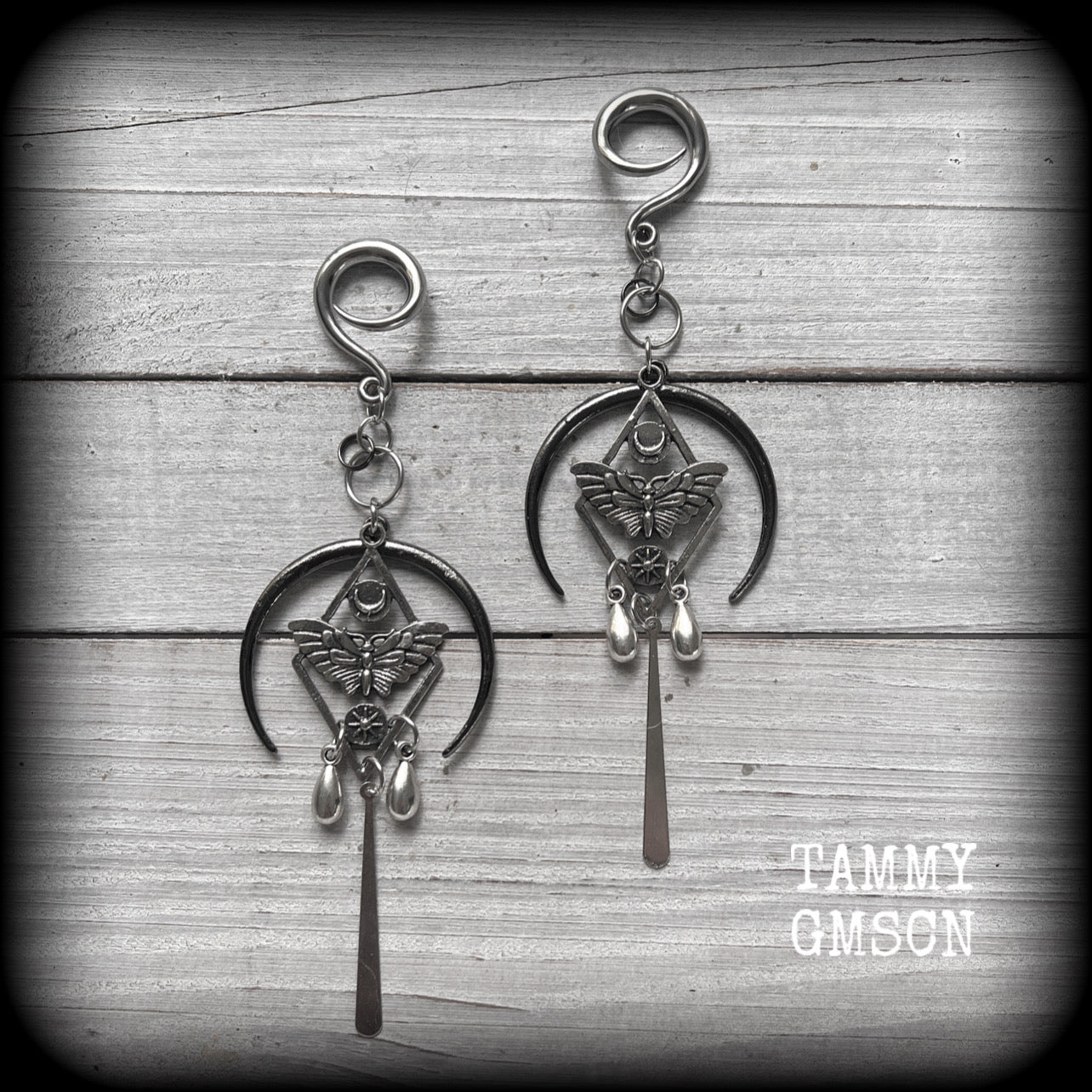 These gorgeous antique silver 'Moth and moon" gauged earrings feature an antique silver moth pendant sitting atop a black inverted crescent moon charm, dripping with antique silver teardrops.
Measuring just under 11cms, weighing approx 11 grams each.