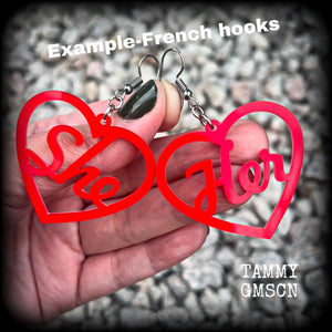 These earrings feature gorgeous bright red hearts showing the pronouns SHE/HER. 
These are nice and lightweight (at only a few grams each), and measure approx 6.5cms from tip to tip.

This pair have been made on stainless steel french hooks, for pierced ears.