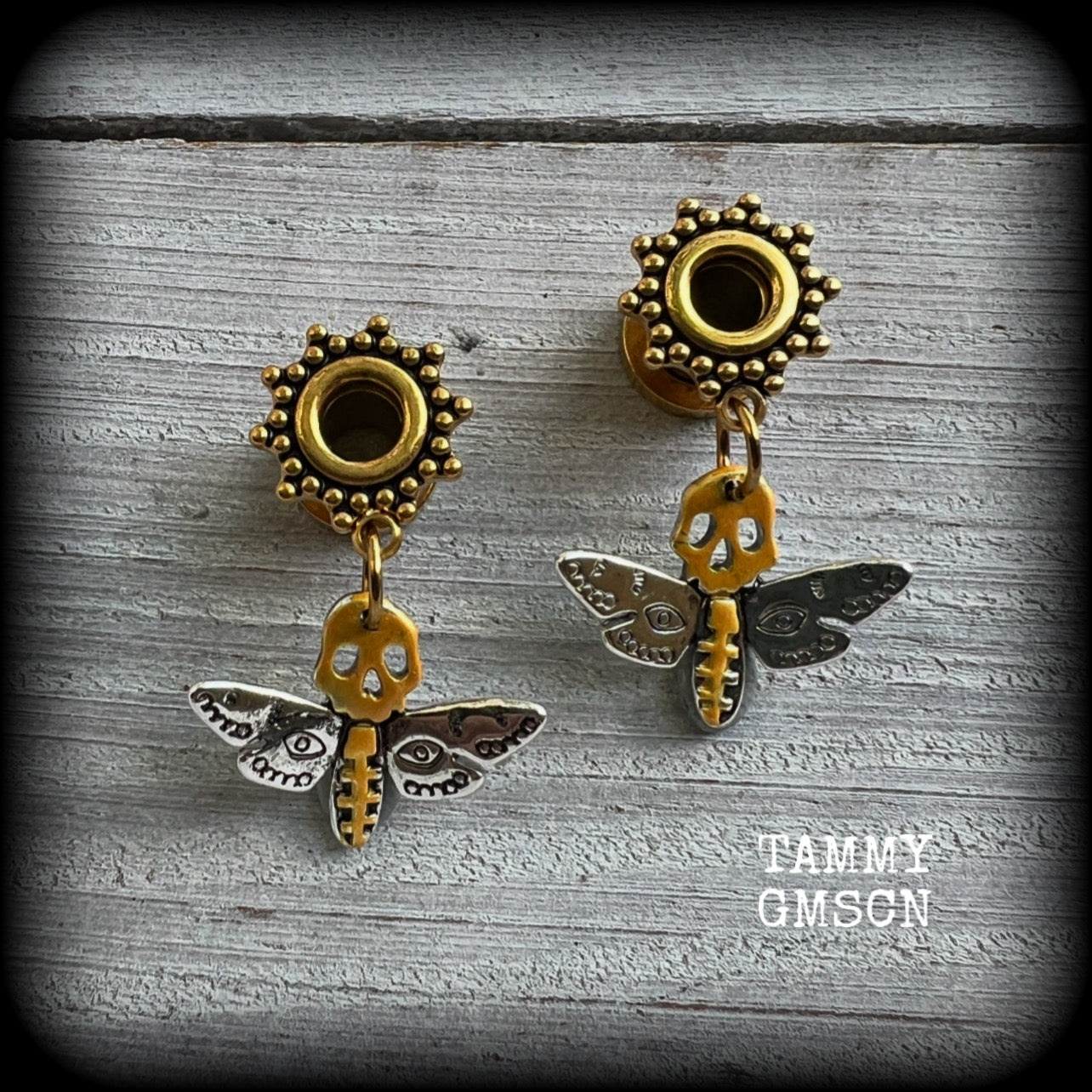 These unique tunnel earrings feature stunning antique silver and hand painted gold enamel deaths head moths, weighing only a few grams each, and measure approx 3cms from tip to tip.

This pair has been made on 2 gauge (6mm) ornate surgical steel screw fit tunnels.