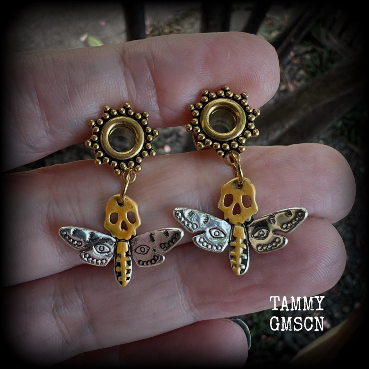 These unique tunnel earrings feature stunning antique silver and hand painted gold enamel deaths head moths, weighing only a few grams each, and measure approx 3cms from tip to tip.

This pair has been made on 2 gauge (6mm) ornate surgical steel screw fit tunnels.