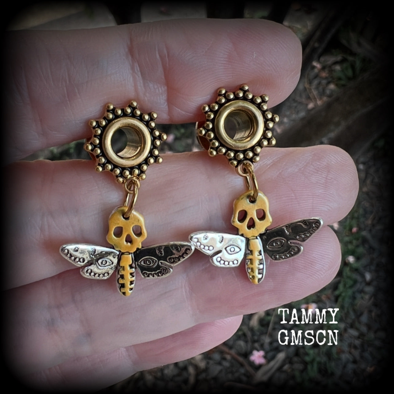 These unique tunnel earrings feature stunning antique silver and hand painted gold enamel deaths head moths, weighing only a few grams each, and measure approx 3cms from tip to tip.

This pair has been made on 2 gauge (6mm) ornate surgical steel screw fit tunnels.