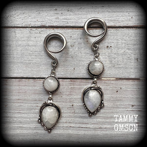 These gorgeous earrings feature polished Rainbow Moonstone gemstones in a beautiful boho antique silver setting, lovely and dangly at approx 8cms from tip to tip, and not too heavy at 9 grams each.
This pair had been made on 6 gauge (4mm) surgical steel full curl hooks, to be worn in stretched lobes.