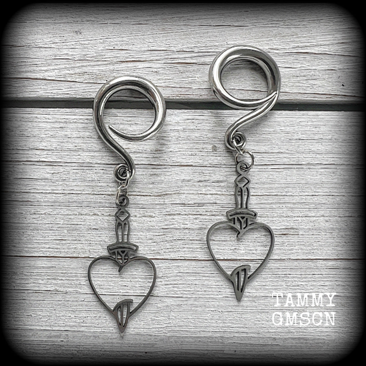 These awesome gauged earrings feature stainless steel heart and dagger charms, are nice and lightweight, weighing only 3 grams a piece, and nice and dangly at just on 6 cms from tip to tip.

This pair has been made on 6 gauge (4mm) surgical steel full curl hooks, suitable for stretched lobes.