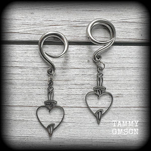 These awesome gauged earrings feature stainless steel heart and dagger charms, are nice and lightweight, weighing only 3 grams a piece, and nice and dangly at just on 6 cms from tip to tip.

This pair has been made on 6 gauge (4mm) surgical steel full curl hooks, suitable for stretched lobes.