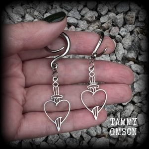 These awesome gauged earrings feature stainless steel heart and dagger charms, are nice and lightweight, weighing only 3 grams a piece, and nice and dangly at just on 6 cms from tip to tip.

This pair has been made on 6 gauge (4mm) surgical steel full curl hooks, suitable for stretched lobes.