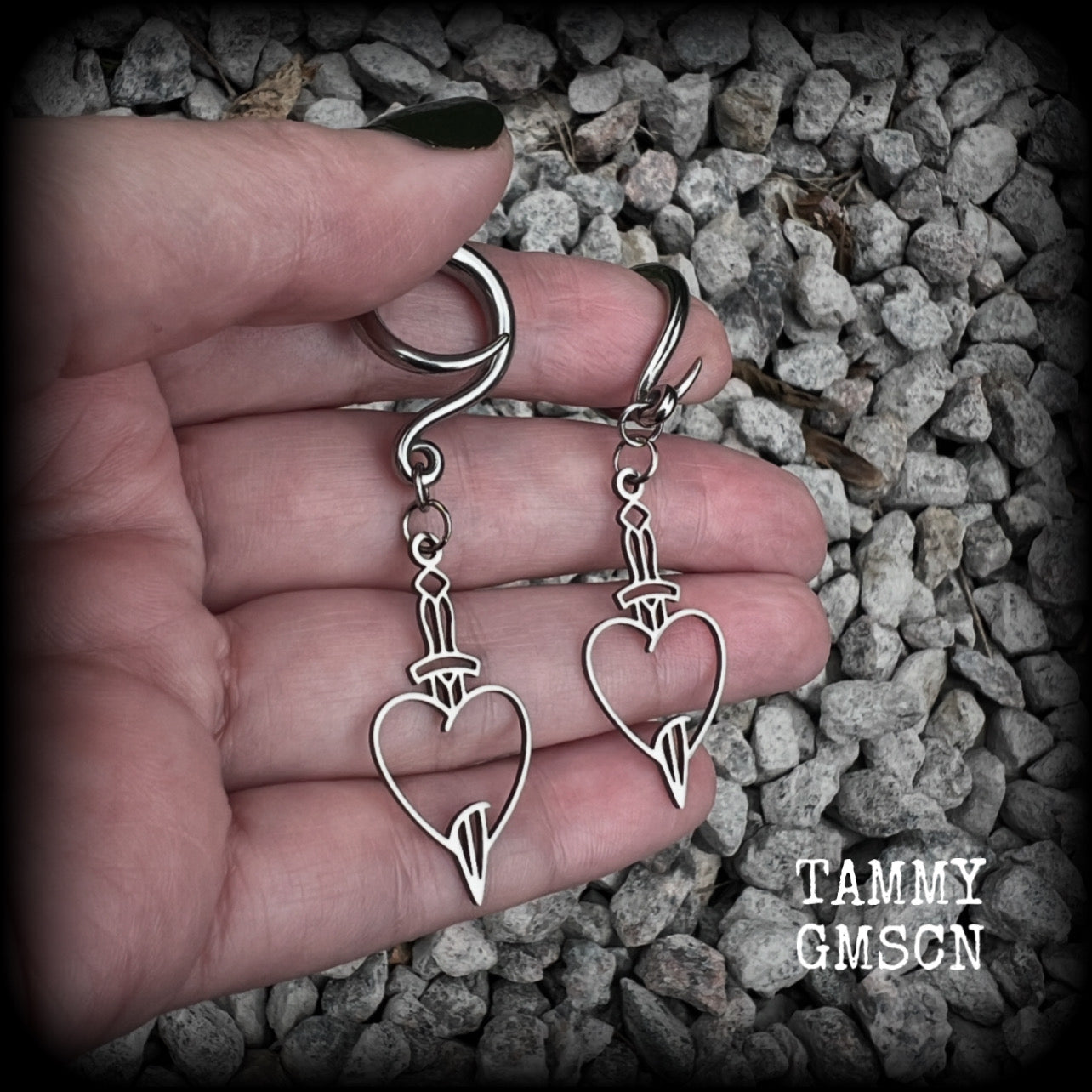 These awesome gauged earrings feature stainless steel heart and dagger charms, are nice and lightweight, weighing only 3 grams a piece, and nice and dangly at just on 6 cms from tip to tip.

This pair has been made on 6 gauge (4mm) surgical steel full curl hooks, suitable for stretched lobes.